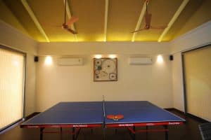 a ping pong table in a room with a clock on the wall